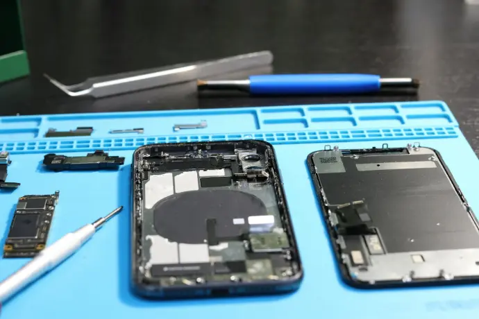 An iPhone is being disassembled for repair.